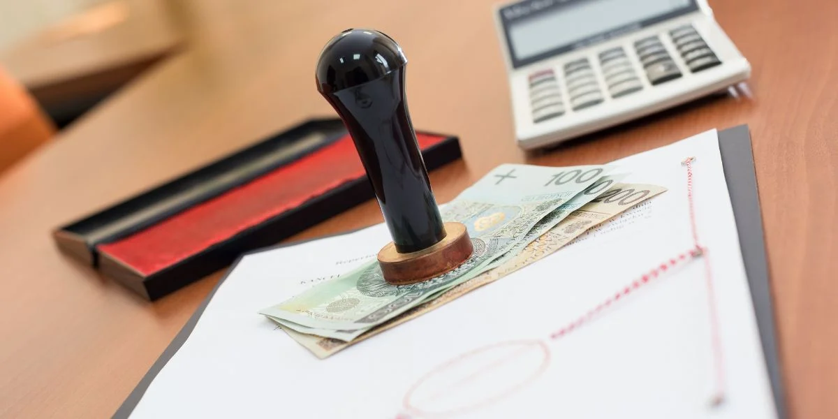 Maryland online notary: rubber stamp on a signed document beside cash and a calculator